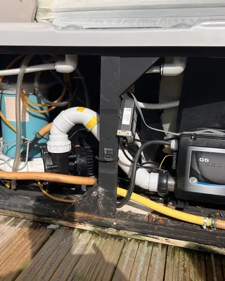 Control pack and pipework inside a hot tub cabinet