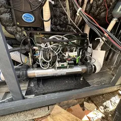 Hot tub control pack and heater inside an opened equipment bay