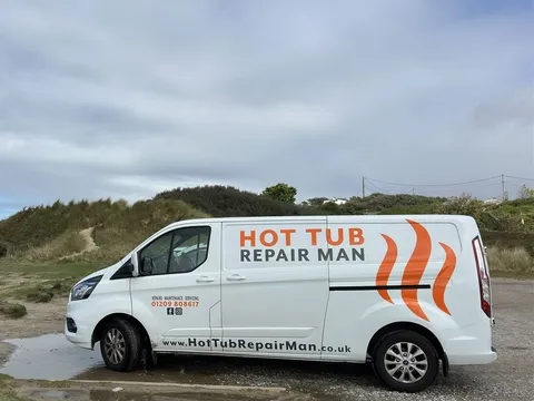 Our white Hot Tub Repair Man van with the orange and grey logo, parked by sand dunes on the Cornish coast
