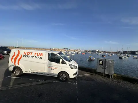 The Hot Tub Repair Man van parked beside a harbour full of boats