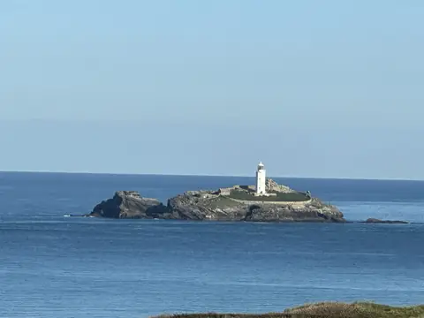 Godrevy lighthouse on its island in St Ives Bay, under a clear blue sky