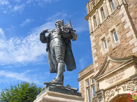 Bronze statue of Richard Trevithick on a stone plinth outside Camborne Library on Cross Street