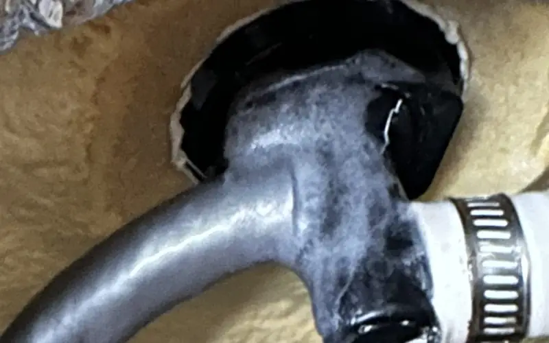 Jet fitting cut out of the foam insulation inside a hot tub, coated in white, crusty deposits