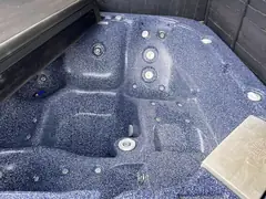 Drained hot tub with a blue speckled shell, ready to be cleaned and refilled