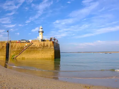 St Ives harbour, with Smeaton’s Pier and its lighthouse, and boats at their moorings